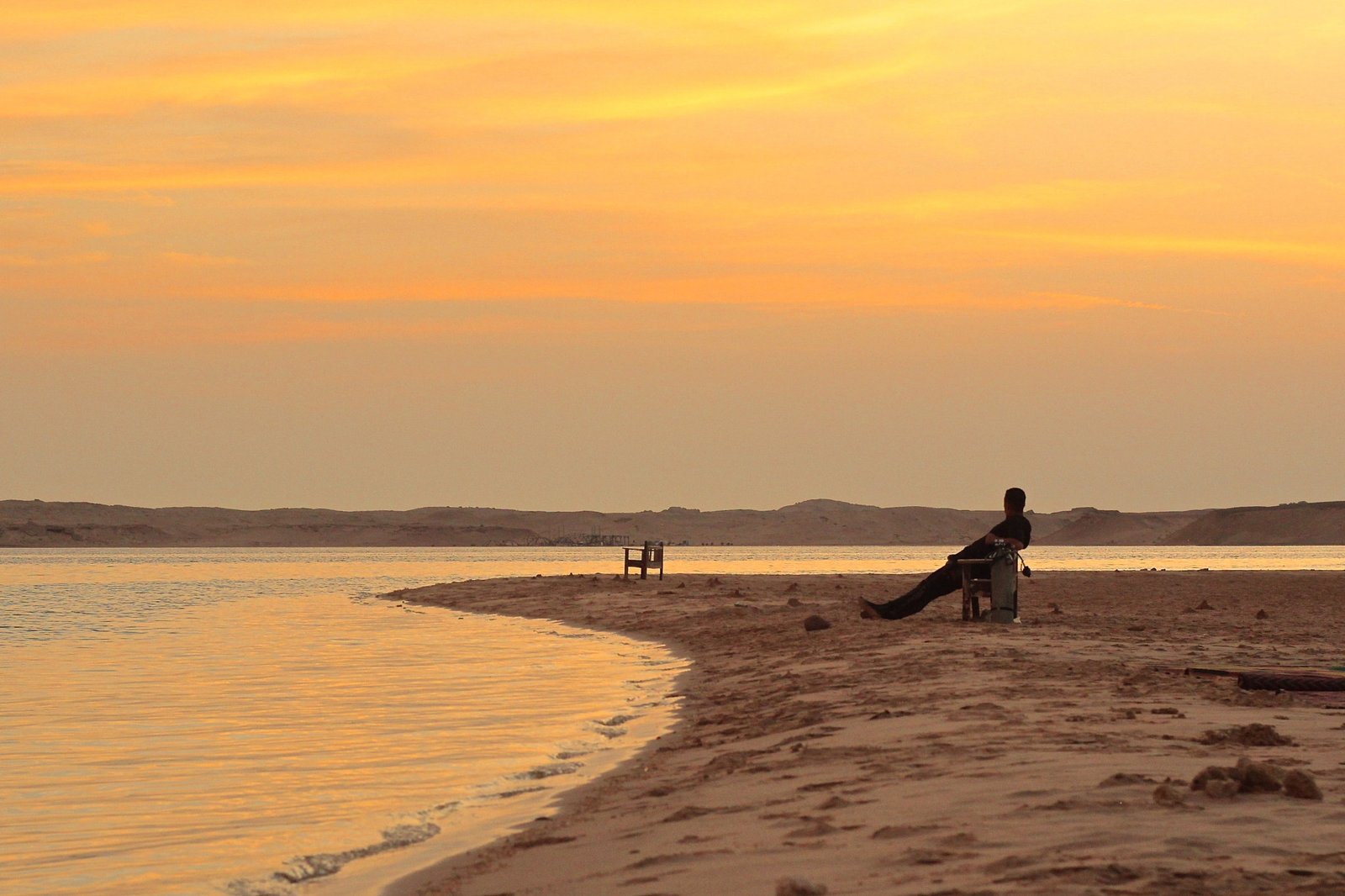 Golden sunset over a quiet beach and still water
